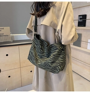 Détail du sac hobo en toile à rayures zébrées vertes avec bandoulière et boucle en métal