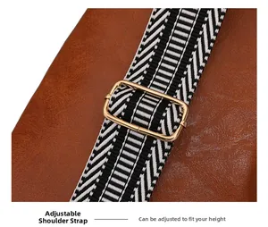 Detail view of brown PU leather bag with black and white geometric pattern strap