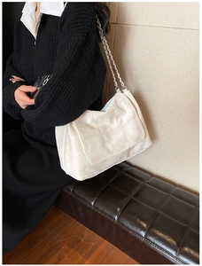 Détail du sac à épaule matelassé blanc en cuir PU avec bandoulière chaîne sur un modèle