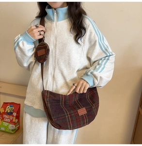 Close-up of red and green plaid woolen crescent bag with a detachable small round coin purse