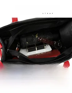 Vue de dessus de l'espace de rangement intérieur du sac bandoulière noir et rouge avec objets