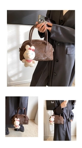Dettaglio della borsa Boston marrone scuro vintage con ciondolo a forma di coniglio peluche