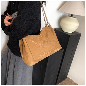 Détail du sac bandoulière matelassé en cuir PU marron avec chaîne et texture vintage