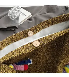 Detail of gold magnetic snaps on brown sherpa bag with colorful star plush charm