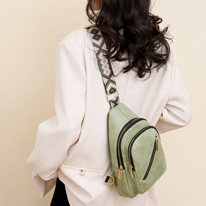 Sage green crossbody bag with ethnic patterned strap and golden zippers, back view detail