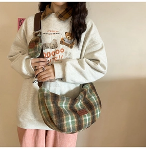 Detail view of plaid wool crossbody bag with a round coin purse and adjustable strap