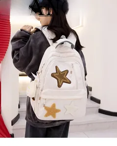 Detailed back view of off-white canvas backpack with plush stars and a cloud charm