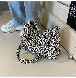 Détail de la bandoulière réglable en toile et boucle argentée sur le sac à main léopard