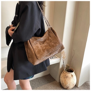 Détail du sac hobo en similicuir marron avec matelassage en losange et bandoulière chaîne