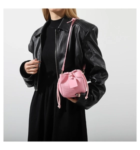 Detail of pink crocodile embossed leather texture on a stylish mini bucket handbag for women
