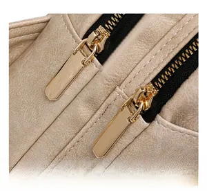 Détails des fermetures éclair dorées sur un sac à bandoulière en cuir beige texturé