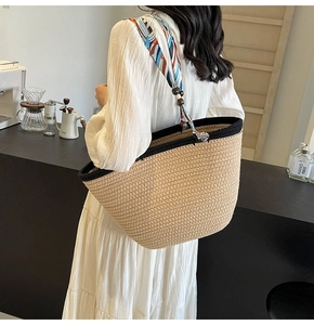 Close-up of woven tote bag with decorative orange and blue silk scarf on the handle