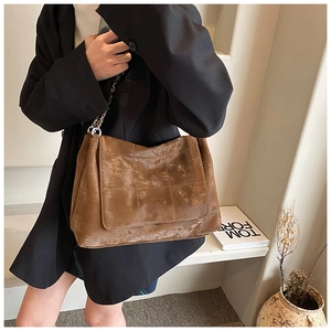 Détail du sac à bandoulière vintage marron en PU avec coutures quadrillées et chaîne