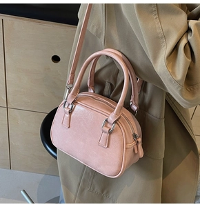 Close-up of small pink bowling bag with textured leather and silver metal hardware details