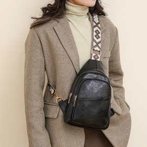 Détail du sac bandoulière noir avec une large sangle tissée aux motifs géométriques