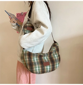 Detail view of plaid wool crossbody bag with mini round pouch and leather logo patch
