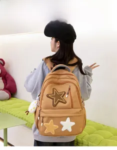 Detailed view of the stylish canvas backpack featuring star patches and a fluffy cloud charm