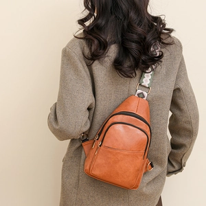 Détail du sac bandoulière en similicuir caramel avec sangle ethnique et multiples zips