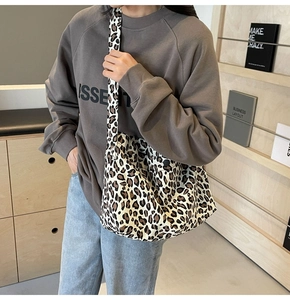 Détail du sac à bandoulière en toile imprimé léopard avec une large sangle réglable
