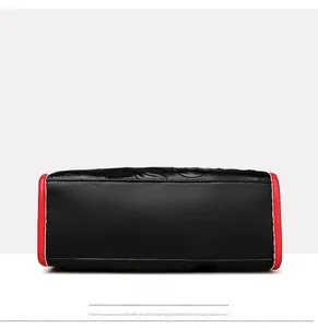 Vue détaillée du fond du sac en cuir litchi noir avec des bords contrastés rouges