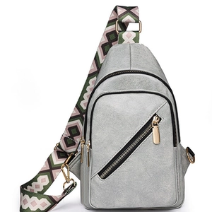 Light gray faux leather crossbody bag with colorful geometric woven shoulder strap
