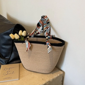 Fashionable woven straw tote bag with silk scarf handle and wooden bead accents