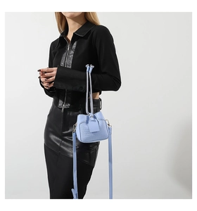 Detail view of light blue crocodile pattern PU bucket bag with adjustable shoulder strap