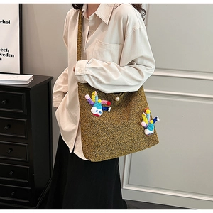 Detail of winter crossbody bag in brown tweed with pearl clasp and cute cartoon pendant