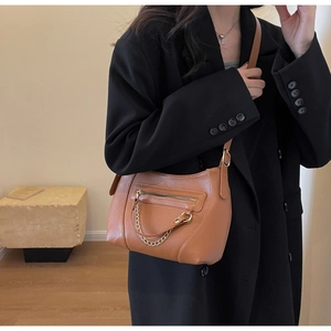 Detail of brown litchi pattern PU leather crossbody bag with golden chain and zipper