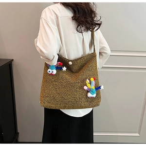 Detailed close-up of brown textured wool bag with colorful cartoon star and eye ornaments