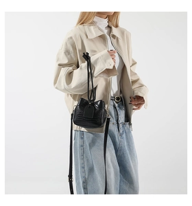 Close-up of black crocodile pattern PU leather crossbody bag paired with casual streetwear