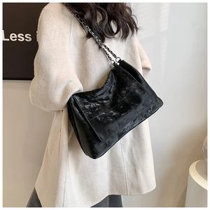 Détail du sac à bandoulière en PU noir matelassé avec bandoulière chaîne argentée