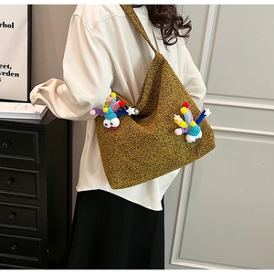 Detail view of mustard yellow textured tote bag featuring vibrant 3D cartoon ornaments