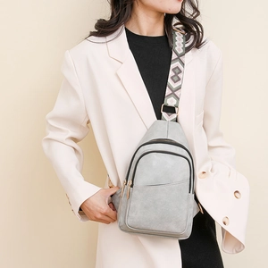 Détail du sac bandoulière gris avec large sangle géométrique et fermoirs dorés