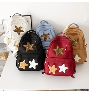 Detail of five colorful canvas backpacks featuring star patchwork and multi-pocket design