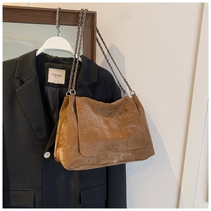 Sac à bandoulière en similicuir marron matelassé avec chaîne suspendu au cintre
