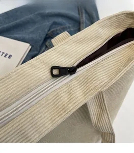 Close-up of smooth metal zipper closure on a corduroy tote bag with dark brown lining