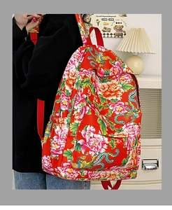 Detalle de la mochila de nailon rojo con estampados de peonías y correa ajustable