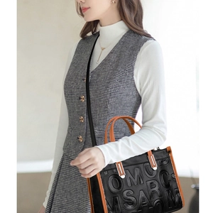 Sac à bandoulière chic en cuir noir avec poignées marron et motif de lettres gaufrées
