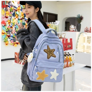 Detail of light purple canvas backpack with star embroidery and plush charm accessory