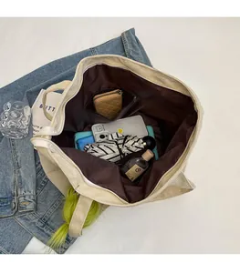Detailed interior of a beige corduroy tote bag showing large storage capacity and inner pocket