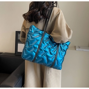 Vue détaillée du sac cabas matelassé bleu métallisé brillant avec de longues anses noires