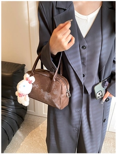 Dettaglio della borsa Boston vintage in pelle PU marrone con un ciondolo a coniglio