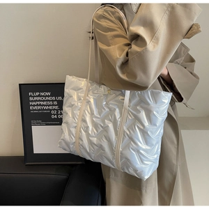 Détail du sac cabas matelassé argenté avec surpiqûres en V et bandoulière en cuir premium