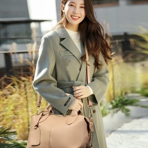 Elegant beige Boston handbag for women paired with light green coat for winter fashion