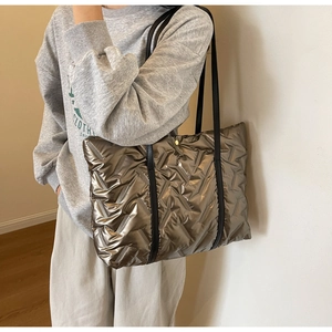 Détail du sac cabas matelassé bronze métallisé montrant la texture et les anses noires