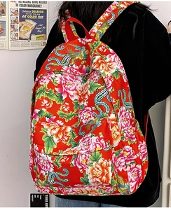 Detalle de mochila roja con motivos florales tradicionales y bordados de fénix