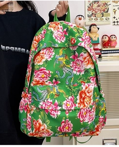 Detalle de una mochila de nailon verde con motivos clásicos de fénix y flores de peonía