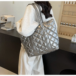 Vue détaillée du sac cabas argenté matelassé avec texture métallique dans un café