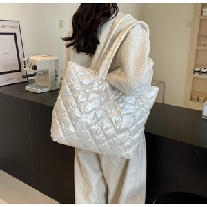 Détail du sac cabas matelassé blanc avec finition brillante et large bandoulière